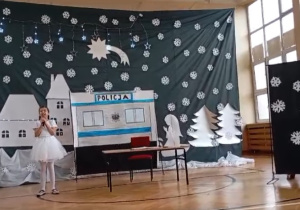 Na zdjęciu widoczna jest uczennica śpiewająca kolędę.