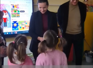 Zdjęcie przedstawiające kobietę, mężczyznę, dwoje dzieci w klasie lekcyjnej