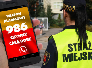 Zdjęcie przedstawiające telefon z numerem telefonu 986 i postać kobiety w kamizelce odblaskowej z napisem "Straż Miejska"