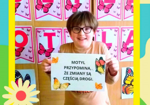 Zdjęcie przedstawia uczennicę trzymającą kartkę z napisem.