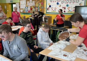 Dzieci siedzące przy stolikach podczas warsztatów.